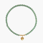 Flat lay of the JUNE ELLE MagMix interchangeable necklace, combining a Green Aventurine bead base chain with a custom gold heart initial charm centerpiece connected by gold magnetic clasps.