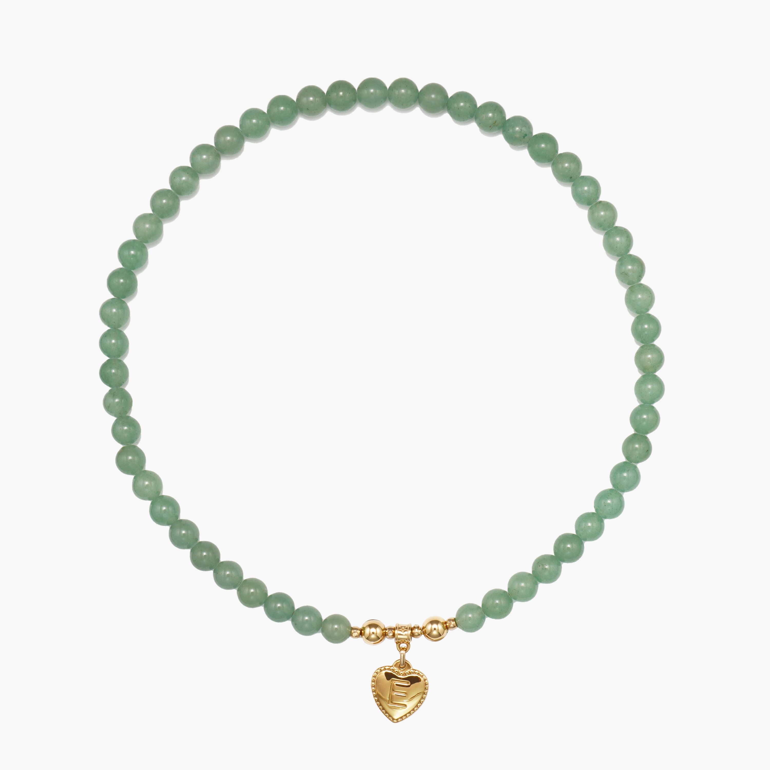 Flat lay of the JUNE ELLE MagMix interchangeable necklace, combining a Green Aventurine bead base chain with a custom gold heart initial charm centerpiece connected by gold magnetic clasps.