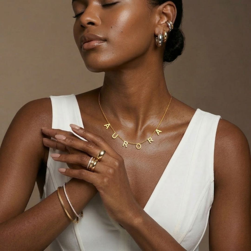 JUNE ELLE gold custom letter name necklace spelling AURORA integrated into chain styled on model natural front view