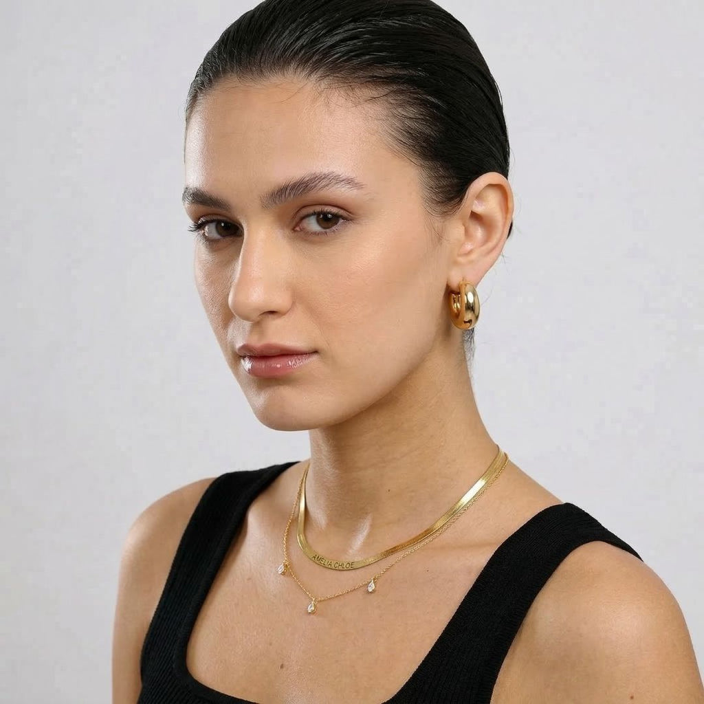 JUNE ELLE gold custom herringbone name necklace worn in layered styling on model side angle