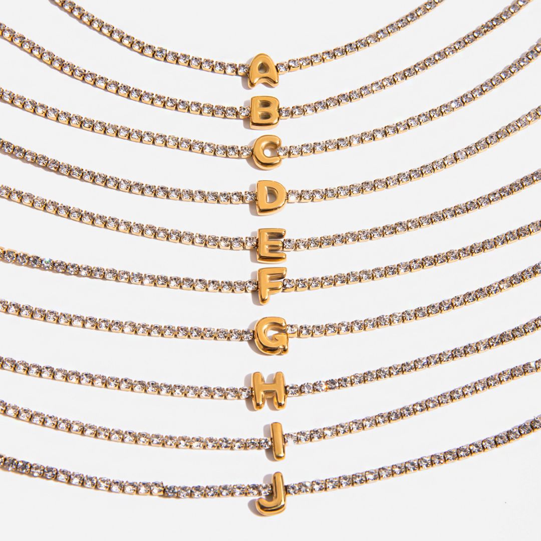 JUNE ELLE gold initial tennis bracelet featuring letters A to J close-up detail view on white background
