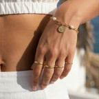 Model wearing the minimalist waterproof 18K gold plated stainless steel custom engraved ring on finger, showing stacking style