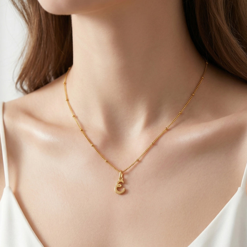 JUNE ELLE gold dearest initial charm letter E on sphere chain necklace worn on model front view