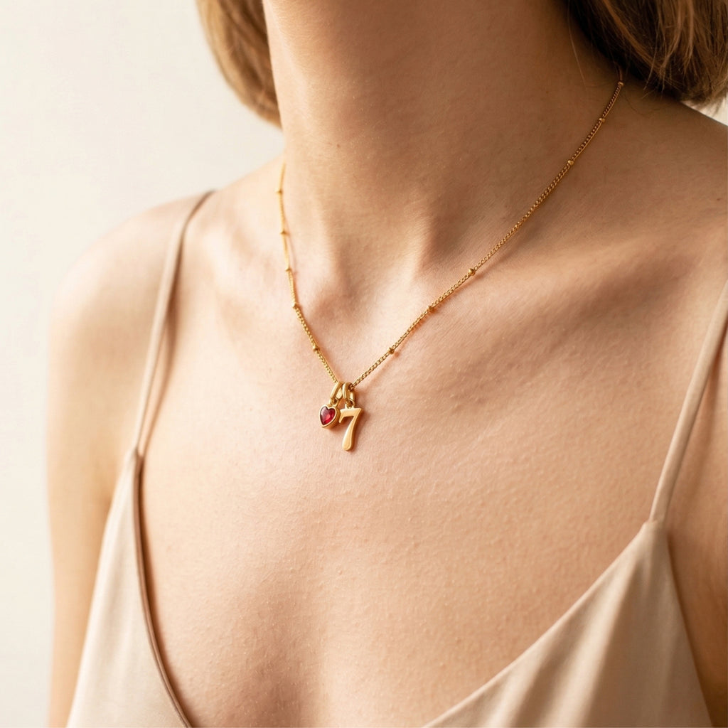 JUNE ELLE gold lucky number charm number 7 and a heart birthstone charm worn on model side view, customizable 0–9