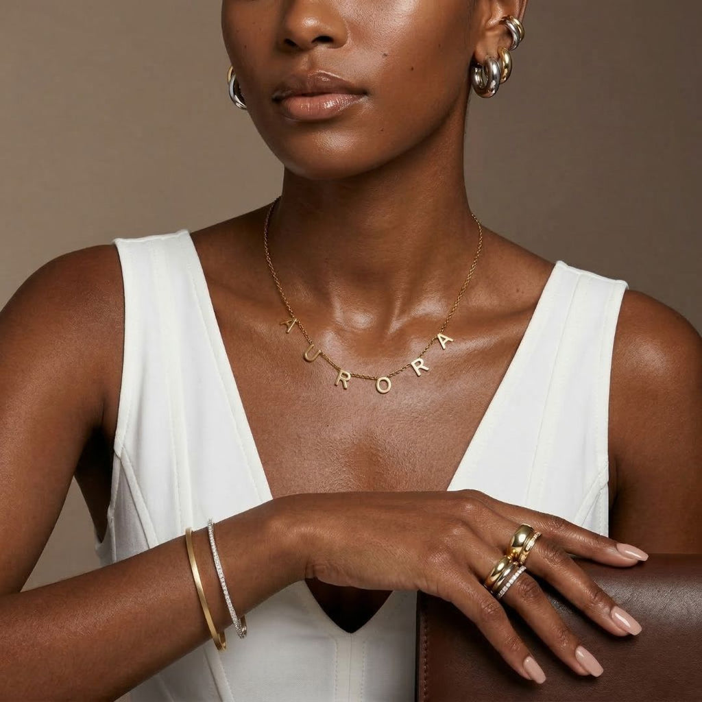 JUNE ELLE gold Isabella custom letter name necklace spelling AURORA with letters integrated into chain worn on model front view