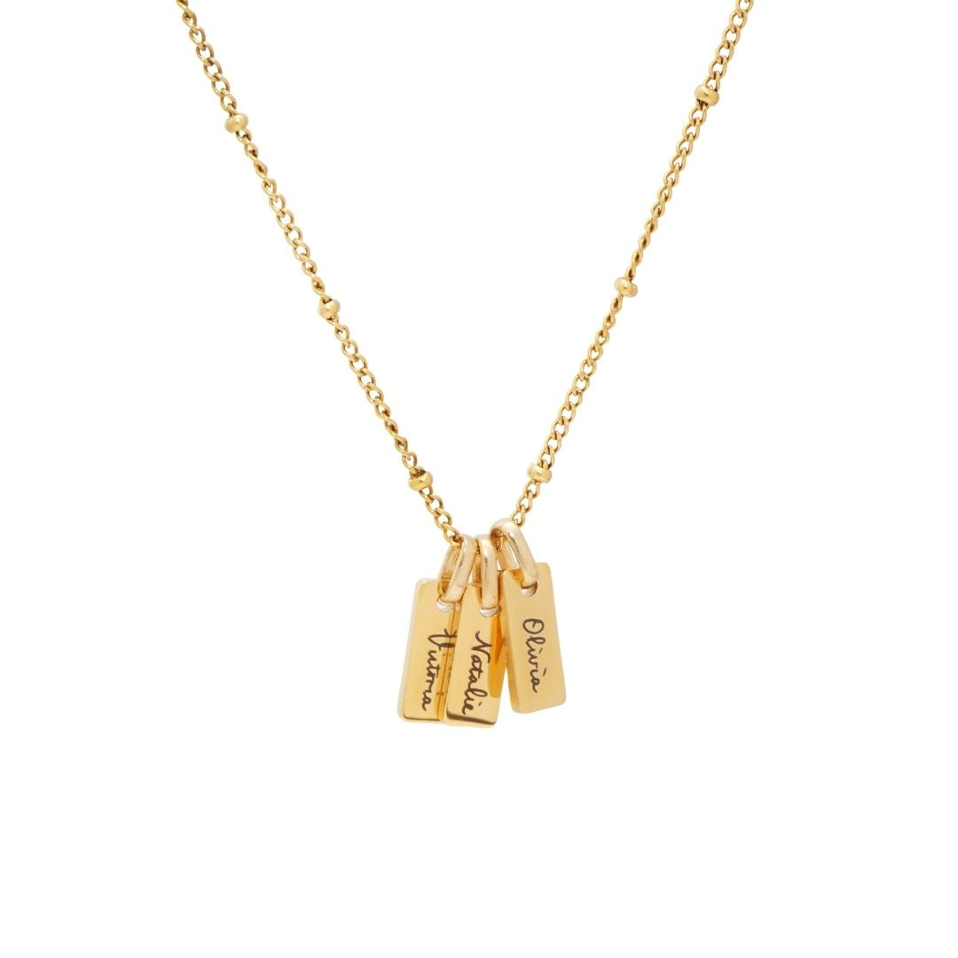 JUNE ELLE Gold Engraved Bar Necklace featuring three personalized nameplates, 'Victoria', 'Natalie', and 'Sophia', on a satellite chain.