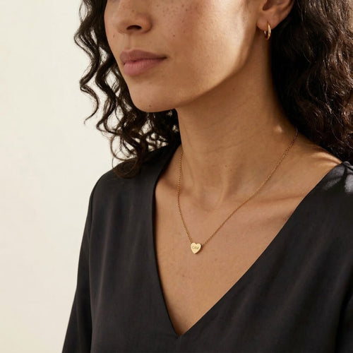 JUNE ELLE gold custom heart necklace engraved with C&M worn on model side view