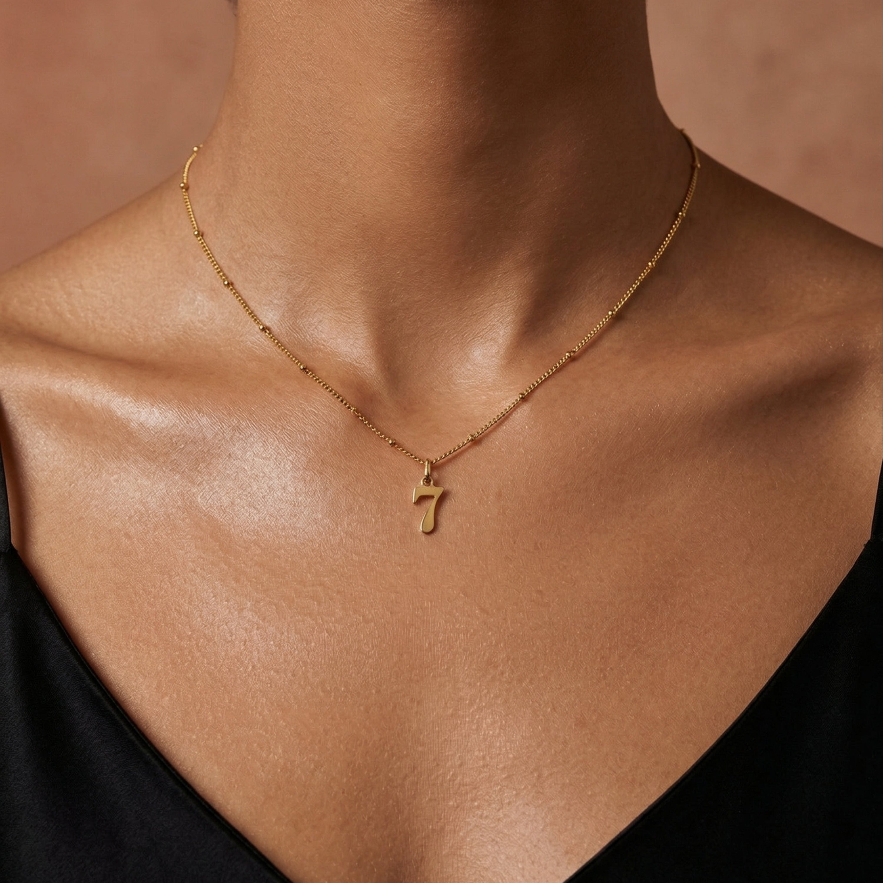 gold lucky number charm featuring number 7 worn on model front view, available in numbers 0–9