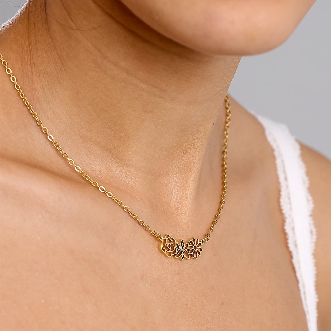 JUNE ELLE gold multiple birth flowers necklace with April Daisy, May Lily and June Rose integrated into chain worn on model close side angle