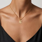 JUNE ELLE gold lucky number charm featuring numbers 4 and 7 worn on model front view, customizable 0–9