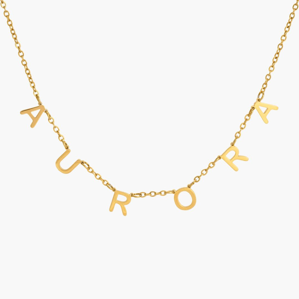 JUNE ELLE gold Isabella custom letter name necklace spelling AURORA as an example with individual letters integrated into the chain front view on white background