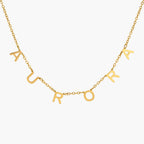 JUNE ELLE gold Isabella custom letter name necklace spelling AURORA as an example with individual letters integrated into the chain front view on white background