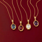 JUNE ELLE 14K gold plated stainless steel birthstone pendant necklaces, 4 different months displayed on burgundy background scene