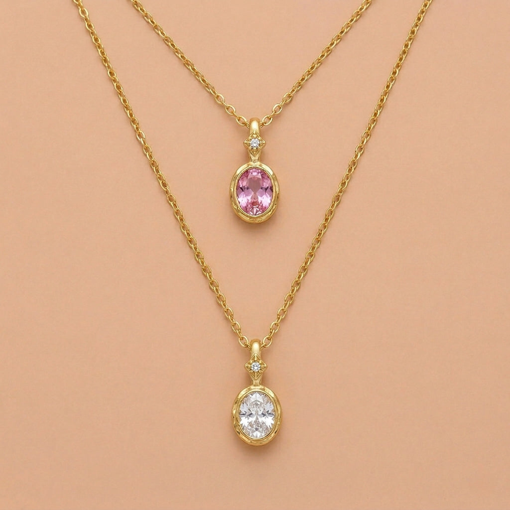 JUNE ELLE 14K gold plated stainless steel birthstone pendant necklaces, 2 different months displayed on light orange background, front view