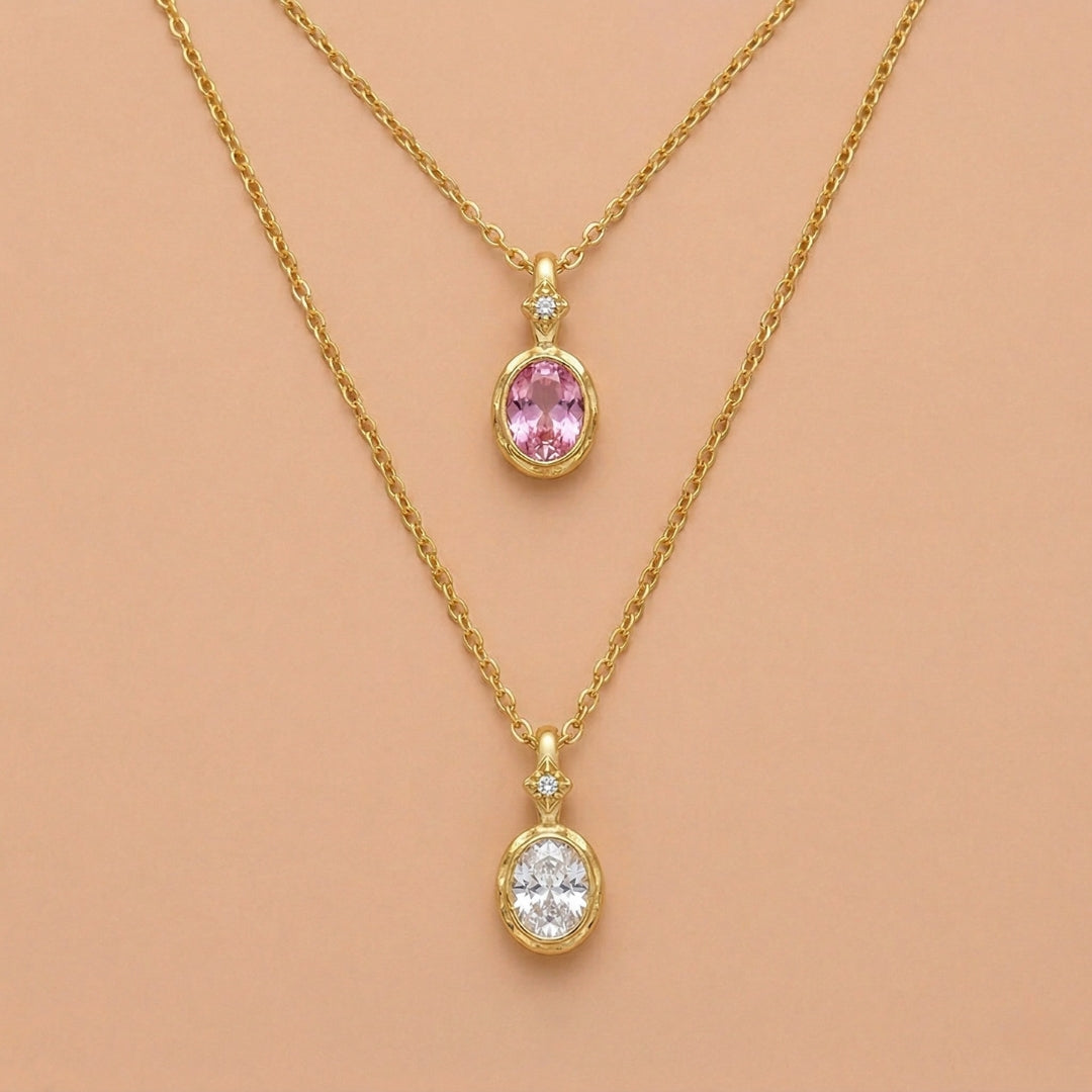 JUNE ELLE 14K gold plated stainless steel birthstone pendant necklaces, 2 different months displayed on light orange background, front view