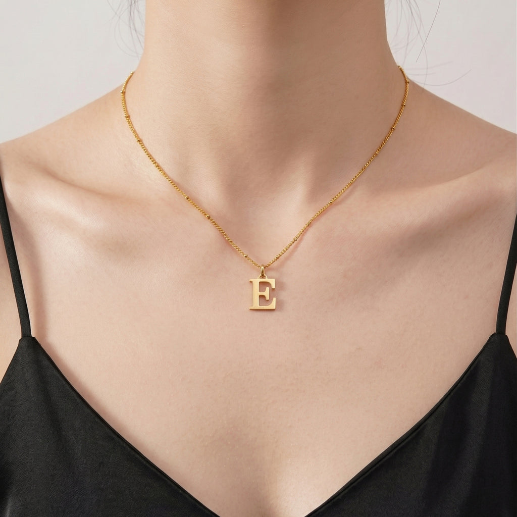Model wearing JUNE ELLE personalized 18K gold plated stainless steel initial pendant necklace, front-facing view
