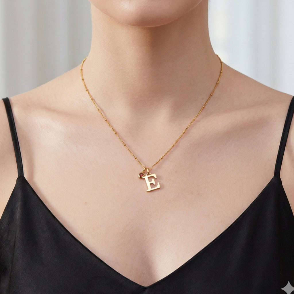 Model wearing JUNE ELLE personalized initial pendant necklace with heart birthstone charm, front view