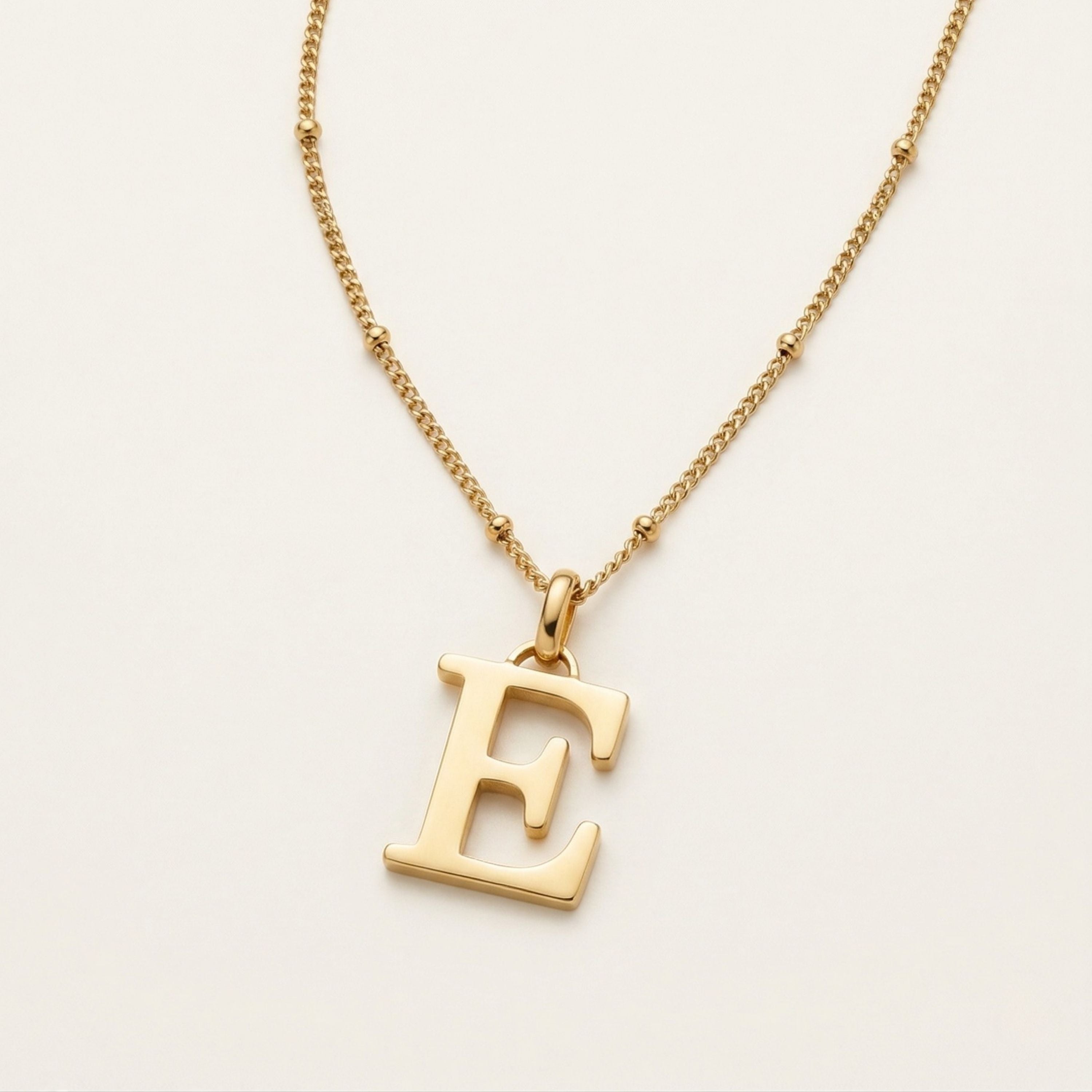 JUNE ELLE 18K gold plated stainless steel personalized initial pendant necklace, custom letter jewelry shown in side angle top-down view