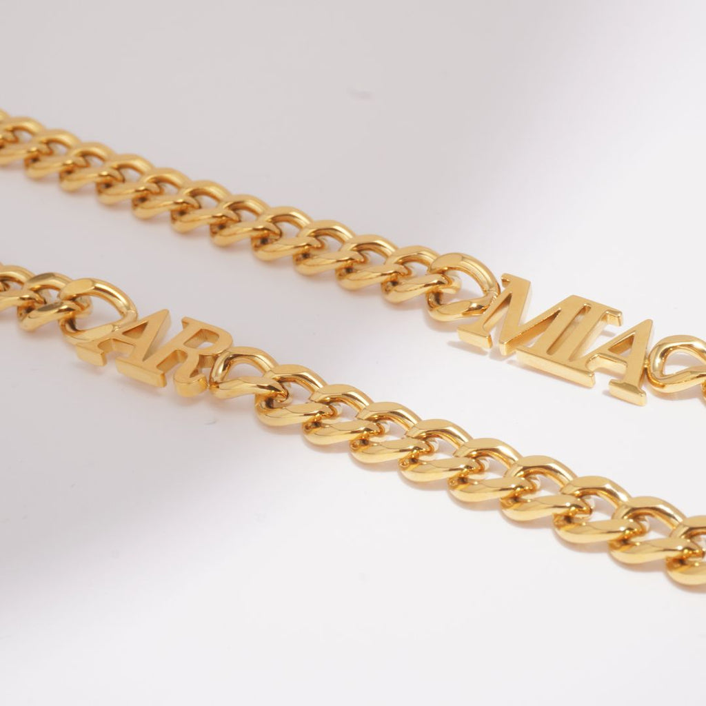 Close-up of a JUNE ELLE 18K gold plated stainless steel curb chain necklace with integrated custom letters.