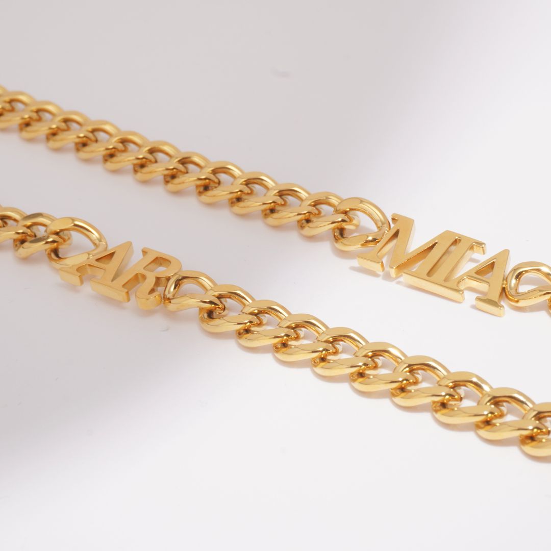 Close-up of a JUNE ELLE 18K gold plated stainless steel curb chain necklace with integrated custom letters.