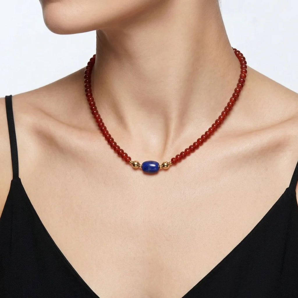 Model wearing the JUNE ELLE MagMix interchangeable necklace, combining a red carnelian bead base chain with a lapis lazuli barrel centerpiece connected by gold magnetic clasps.