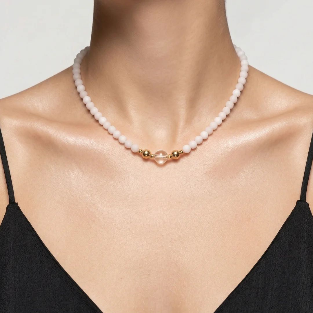 Model wearing the JUNE ELLE MagMix interchangeable necklace, combining a soft pink Rose Quartz bead base chain with a clear quartz centerpiece connected by gold magnetic clasps.