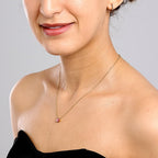 Close-up of a model wearing a custom waterproof 18K gold PVD Toi et Moi necklace with pink birthstones